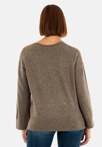 Maglione marrone chiaro con una texture morbida, scollatura ampia e orlo a costine. Maniche lunghe e vestibilità rilassata progettata per il comfort.
