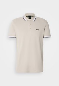 Polo beige à manches courtes avec col et poignets blancs bordés de noir, trois boutons et logo noir "BOSS" sur la poitrine gauche.