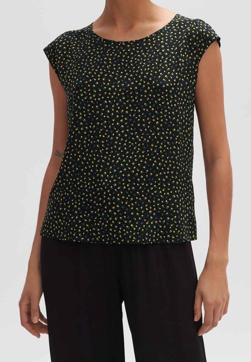 Maglietta nera a maniche corte, con un motivo a pois gialli e verdi. Tessuto liscio, vestibilità ampia, scollatura rotonda.