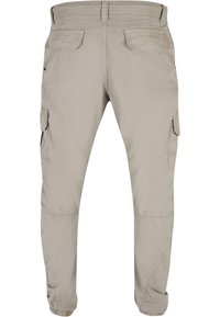 Beige Cargo-Hosen mit lockerer Passform, ausgestattet mit zwei seitlichen Taschen und zwei Gesäßtaschen, elastischen Bündchen an den Knöcheln sowie einem glatten Stoff.