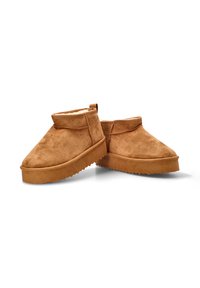 Botas de tobillo de ante en tono tierra con un suave forro de shearling, puntera redondeada y una suela de goma gruesa y texturizada. Diseño de cuello corto y sin costuras.