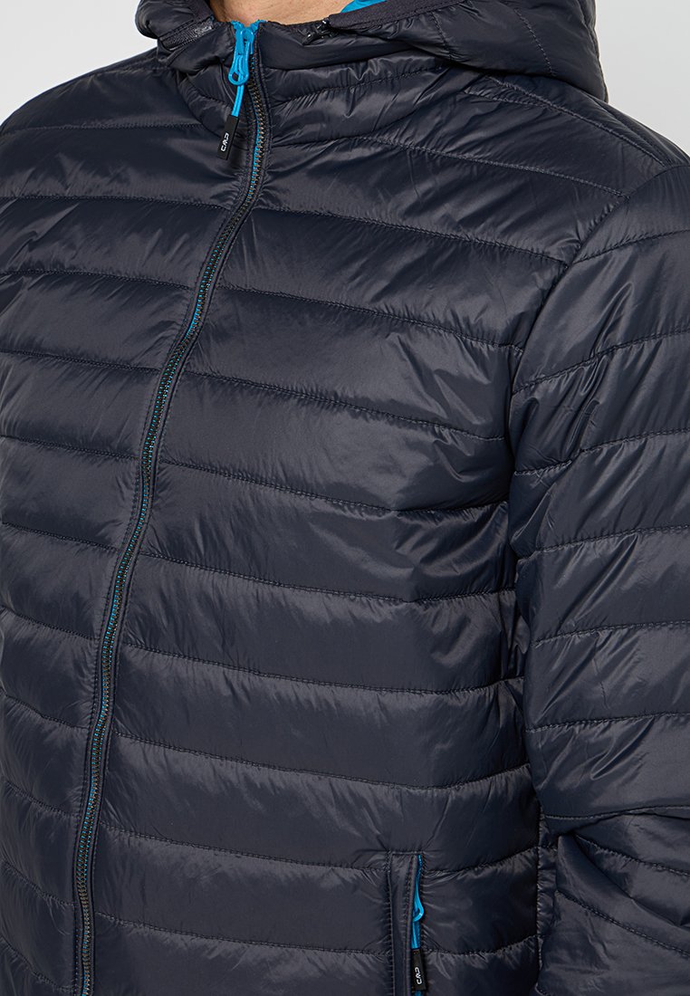 Giacca imbottita blu scuro con cappuccio, caratterizzata da un design a righe orizzontali, materiale leggero e zip e dettagli blu in contrasto.