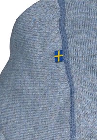 Lys blå strikket stof med en tekstureret finish. Har et lille svensk flag-label på siden, tættere på en søm med blå syninger.