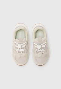 Lyse beige sneakers med mesh- og semsket lærpaneler, runde lisser, polstret krage og en strukturert såle. Inkluderer merking på tungen.