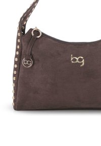 Bolso de ante marrón oscuro con tachuelas doradas a lo largo de la correa, logo "bg" en dorado y tirador de cremallera redondo con el logo a juego.