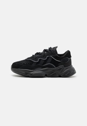 Schwarze Sneaker mit einem Obermaterial aus Mesh und Wildleder, runder Zehenpartie, dickem strukturiertem Sohlen und kontrastierenden Gummi-Akzenten. Verfügt über eine Schnürung.