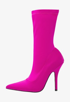 Bottines fuchsia avec un bout pointu élégant et un talon aiguille haut. Fabriquées en tissu lisse et extensible avec un design sans couture.
