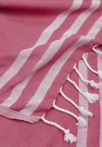 Tessuto a righe rosa e bianche con bordi frangiati, caratterizzato da una trama intrecciata e una finitura liscia. Il design presenta righe alternate spesse e sottili.