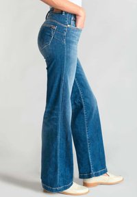 Jeans a zampa d'elefante blu realizzati in denim, con vita alta, aree sbiadite, due tasche frontali e dettagli di cucitura minimi.