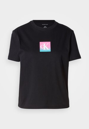 Zwarte katoenen t-shirt met een ronde halslijn. Heeft een vierkant logo in roze en blauw met de tekst "cK" in het midden. Korte mouwen en een relaxte pasvorm.