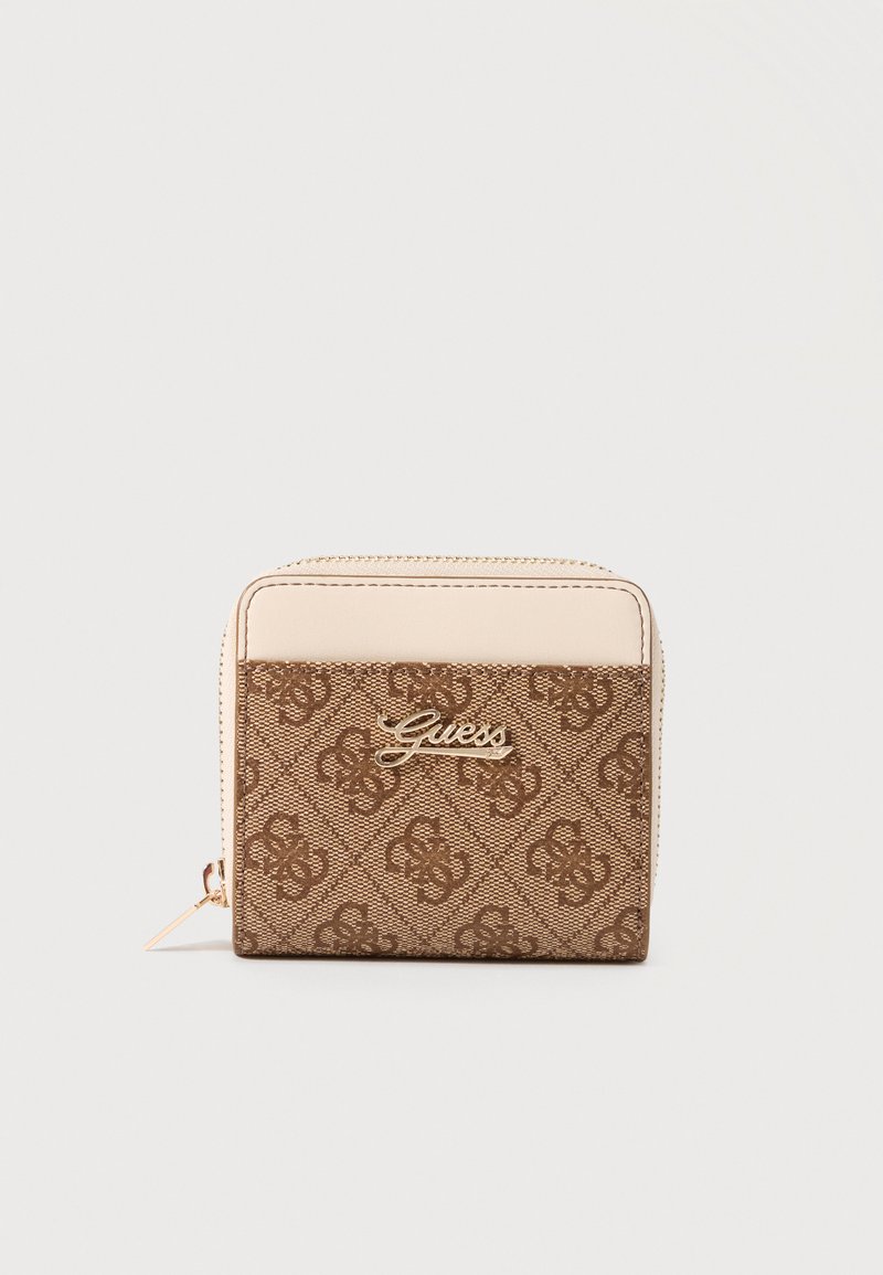 Portefeuille compact beige et marron Guess avec motif de logo répétitif, plaque logo dorée et fermeture éclair sur fond beige.