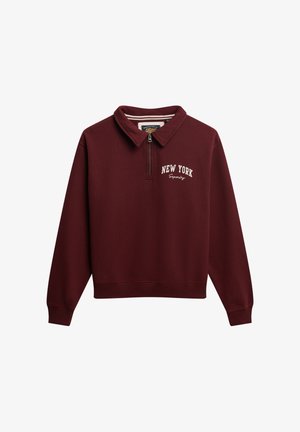 Sweatshirt bordeaux avec col zippé mi-hauteur et texte blanc "New York Superdry" sur la poitrine gauche.