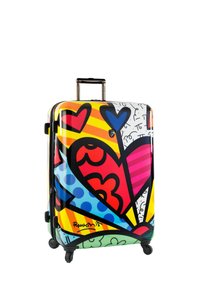 Maleta rígida con un colorido patrón gráfico que presenta corazones, rayas y espirales; equipada con un asa retráctil y ruedas.