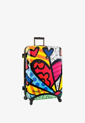Valise rigide avec un motif graphique coloré comportant des cœurs, des rayures et des tourbillons ; équipée d'une poignée télescopique et de roues.