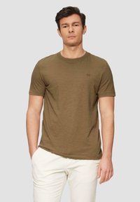 T-shirt vert olive à manches courtes avec un col rond et un logo subtil sur la poitrine. Tissu doux et texturé avec une coupe décontractée.