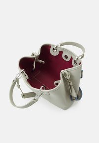 Vaaleanharmaa nahkainen olkalaukku, jossa on punainen sisusta, hopeiset metalliosat ja kaksi kahvaa; laukussa on kaareva yläaukko ja koristeelliset yksityiskohdat.