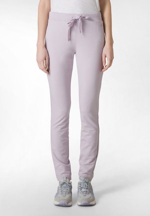 Svetle levandulové joggers s páskem na stažení, slim fit a pružným materiálem, doplněné o šedé a zelené sportovní boty.