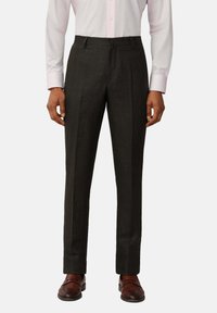 Pantaloni su misura grigio scuro realizzati in un tessuto dalla trama liscia, con una vestibilità dritta e una piega sul davanti. Abbinati a scarpe marroni.