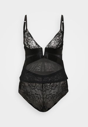 Musta bodysuit, jossa on pitsinen yläosa, syvä V-aukko ja puoliläpinäkyvä paneeli. Koristeltu kukkakuvioisilla pitsikuvioilla ja satiinivyötäröllä.