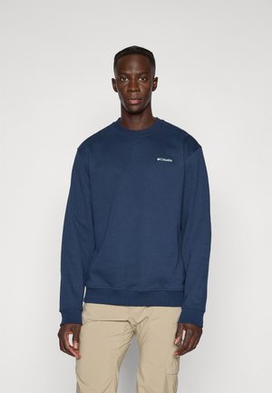 Marineblauwe sweatshirt met ribbelmanchetten en -zoom; heeft een klein logo op de linkerborst. Zachte stof en een klassieke ronde hals.