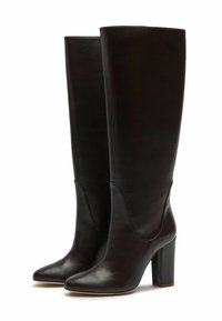Botas negras de cuero hasta la rodilla con puntera afilada y tacón cuadrado. Textura lisa con un sutil detalle de costura a lo largo de la parte superior.