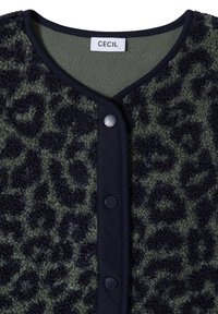 Gros plan d'une veste polaire imprimé léopard vert et noir avec bordure noire et boutons-pression sur le devant, étiquetée "CECIL" à l’intérieur de l’encolure.