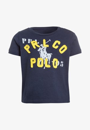 Camiseta de manga corta azul marino con texto amarillo bordado "PRL CO" y "POLO" junto a un gráfico de un jugador de polo gris. Material de algodón suave.