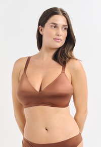 Brązowy bezprzewodowy stanik o dekolcie w kształcie V, gładkiej fakturze, regulowanych ramiączkach i minimalistycznym stylu. W komplecie z pasującymi majtkami.