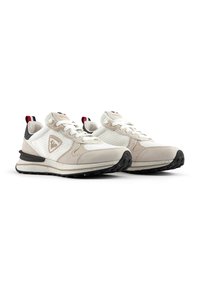 Beige and white athletic shoes with mesh and suede textures, black soles, and a logo on the side; features red and blue accents at the heel.