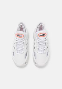 Vita atletiska sneakers med meshpaneler, snördesign och dämpad sula. Har en synlig "CLIMACOOL"-logotyp i orange och svart.