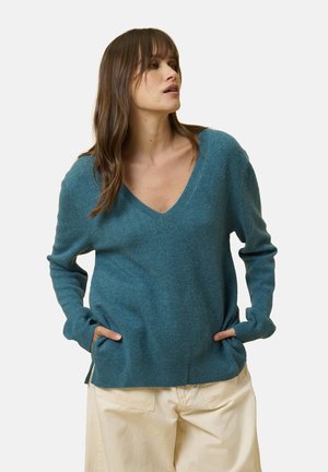 Teal kashmir-pullover med V-udskæring, lange ærmer og sidelommer. Ribbet kant og manchetter, blød tekstur, afslappet pasform.