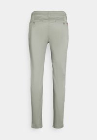 Light grey, slim-fit pants with a smooth texture, back pockets, and subtle stitching details. Designed for a fitted style.