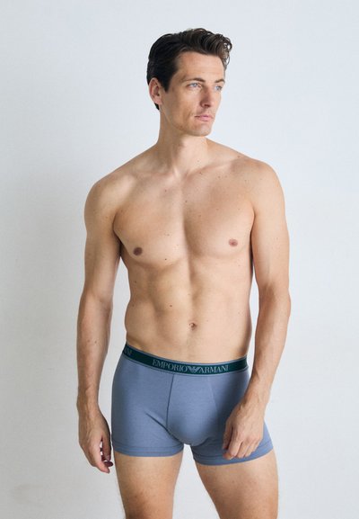 Graue Boxershorts mit einem grünen Logo-Bund, aus einem weichen Stoff gefertigt, mit einer engen Passform und einer glatten Textur.