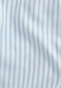 Biela látka s tenkými vertikálnymi modrými pásikmi, ktorá zobrazuje mierne záhyby a detaily textúry.