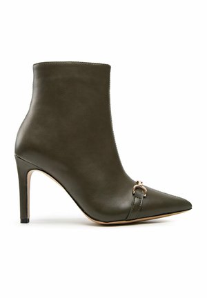 Ciemnozielony skórzany botek na wysokim obcasie z noskiem w szpic i ozdobną metalową klamrą z przodu.