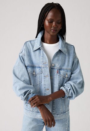 Lyseblå denimjakke med sølvdetaljer, krage, knappelukking og oversized ermer for en avslappet passform.