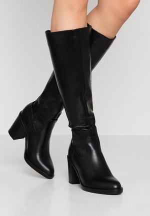 Botas negras hasta la rodilla, fabricadas en cuero liso, con un tacón ancho, punta afilada y detalle de cremallera lateral.