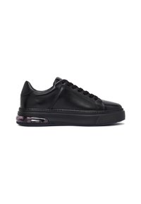 Zapatilla de cuero negro con suela gruesa y amortiguación de aire visible en el talón, diseño con cordones y punta redondeada.