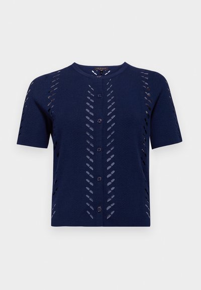 Jūras spēku zila adīta kardigāna jakas ar īsām piedurknēm, kurai ir izgrieztu rakstu detaļas un pogu aizdare priekšpusē. Mīksts, teksturēts audums ar pieguļošu siluetu.