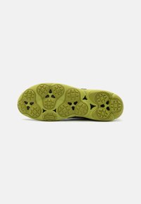 Suola di scarpa con un grip in gomma testurizzata di un vivace verde lime, che presenta punti di trazione multiformi e una forma ben definita.