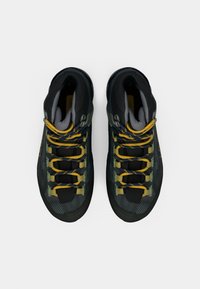 Melni un pelēki augstie pārgājienu apavi ar dzeltenām un zaļām auklām, teksturētām rakstām, mīkstinātu apkakli un izturīgu gumijas zoli.