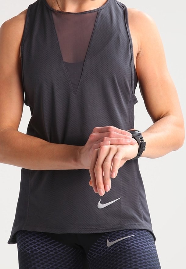 Czarny sportowy top bez rękawów z wstawką z siateczki i dekoltem w kształcie litery V. Posiada logo Nike na dolnej części przodu, zestawiony z wzorzystymi legginsami.