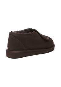 Brown suede slipper with a soft, furry lining, back view shows a rounded shape, textured material, and a flat rubber sole.