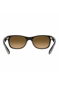 Occhiali da sole neri con un design elegante e arrotondato. Lenti color marrone a tonalità e aste nere lucide con motivi sottili. Accenti in metallo presenti.