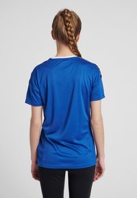 Blå sportt-shirt med kort ärm, rund halsringning och kontrasterande vit kant; glatt tyg med en lätt lyster; inga synliga mönster.