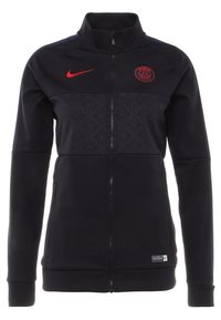 Veste de sport zippée noire avec logo Nike rouge et blason du club de football de Paris, panneau central à motifs et poignets et ourlet côtelés.