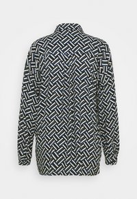 Langarmshirt, zwarte basis met geometrisch blauw en wit patroon. Beschikt over een kraag en een relaxte fit. Soepele stoftextuur.