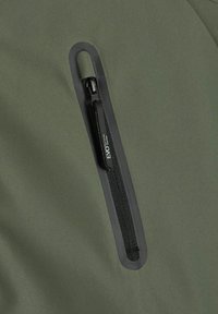 Zielony materiał wodoodpornej kurtki z zamkniętą kieszenią z czarnym zamkiem błyskawicznym. Gładka tekstura z matowym wykończeniem. Minimalistyczny design.