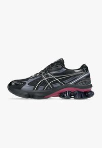 Scarpe da corsa con tomaia in rete nera, dettagli in argento e una suola testurizzata nera e viola. Design leggero con una forma slanciata.