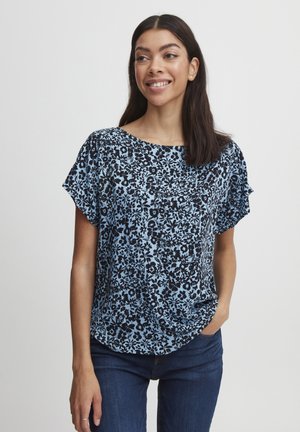 Haut à imprimé floral en bleu clair avec des motifs noirs, à manches courtes et à encolure ronde. Le tissu semble léger avec une texture lisse.